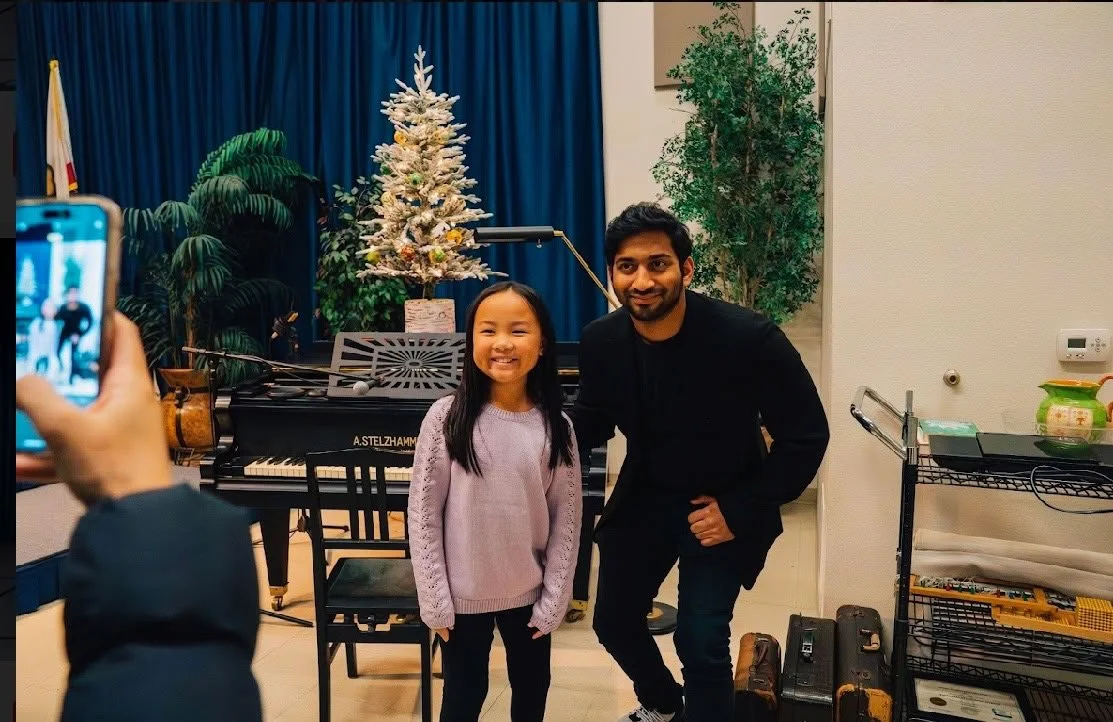 A piano teacher and student posing for a picture after a winter recital.