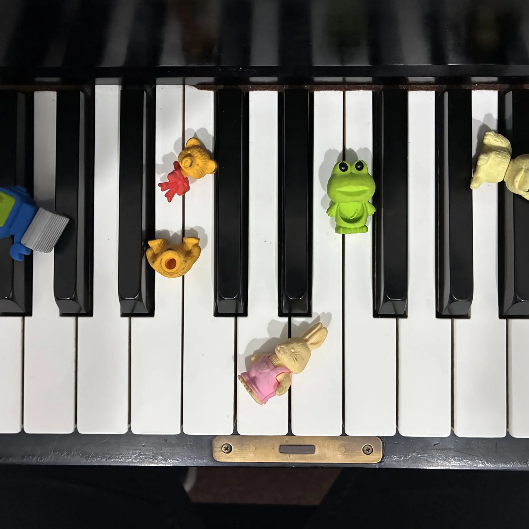 A piano keyboard with small figurines placed on the keys