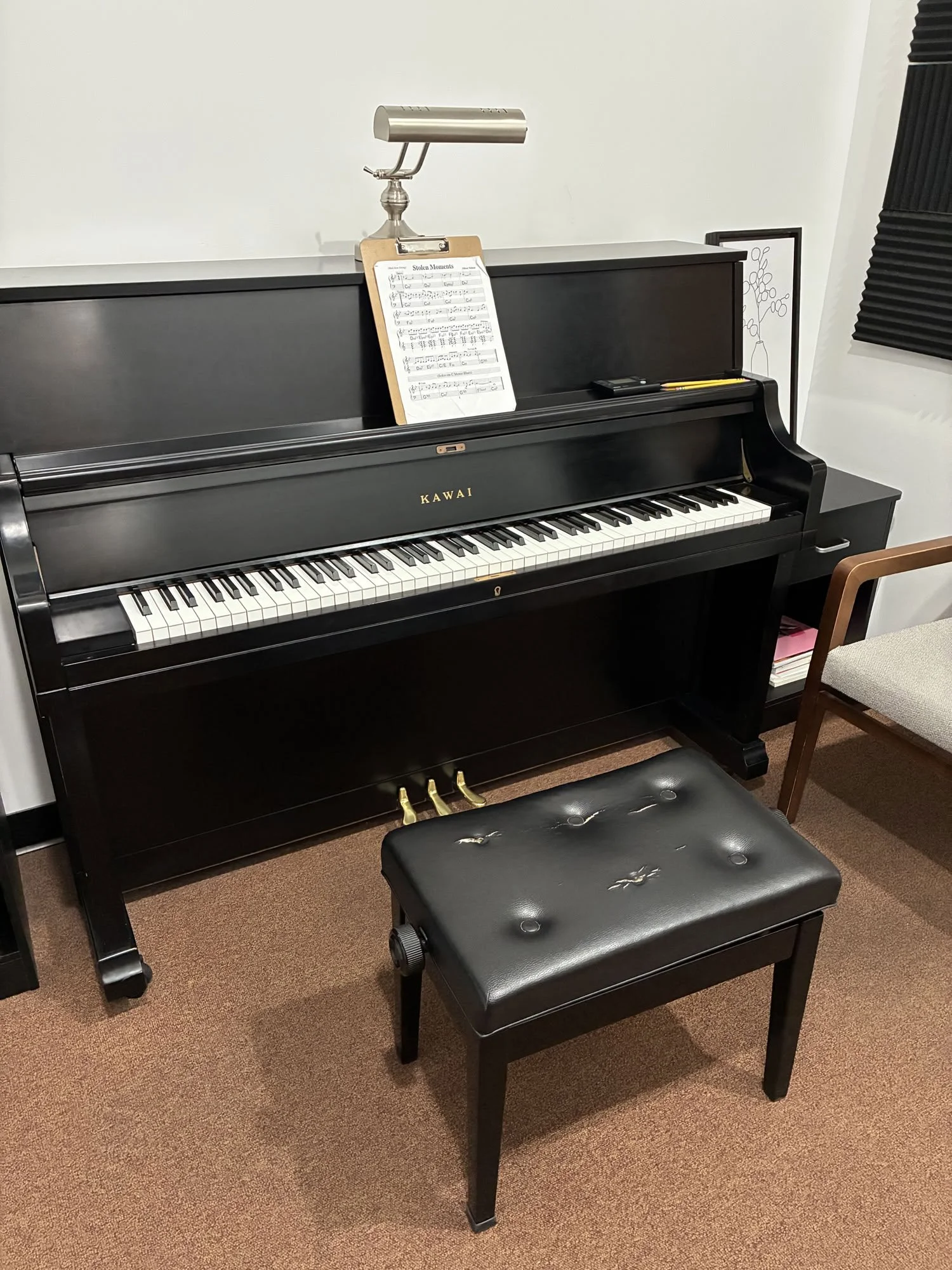 Black upright Kawai piano in a music practice