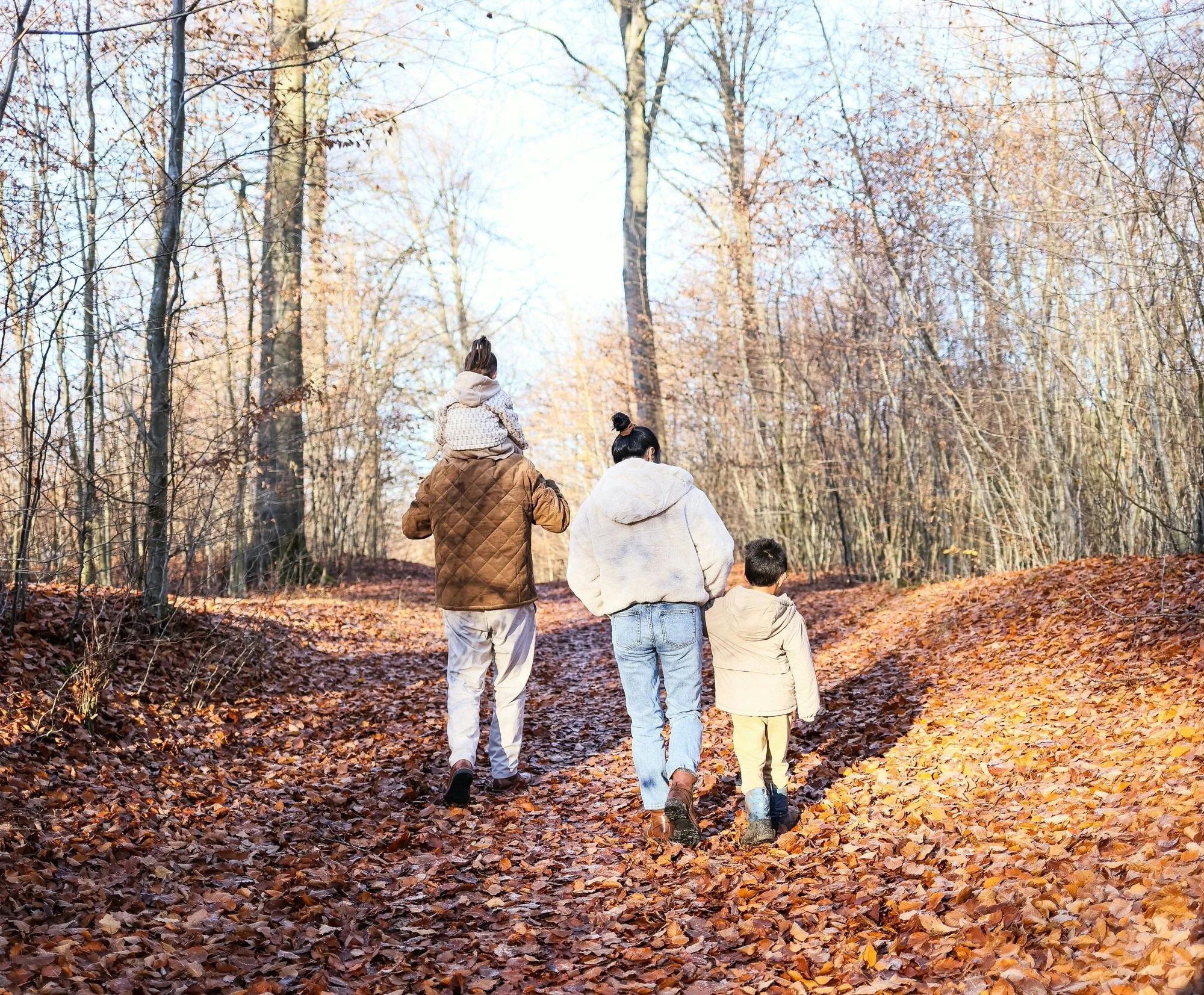 A family walks through the woods together.
