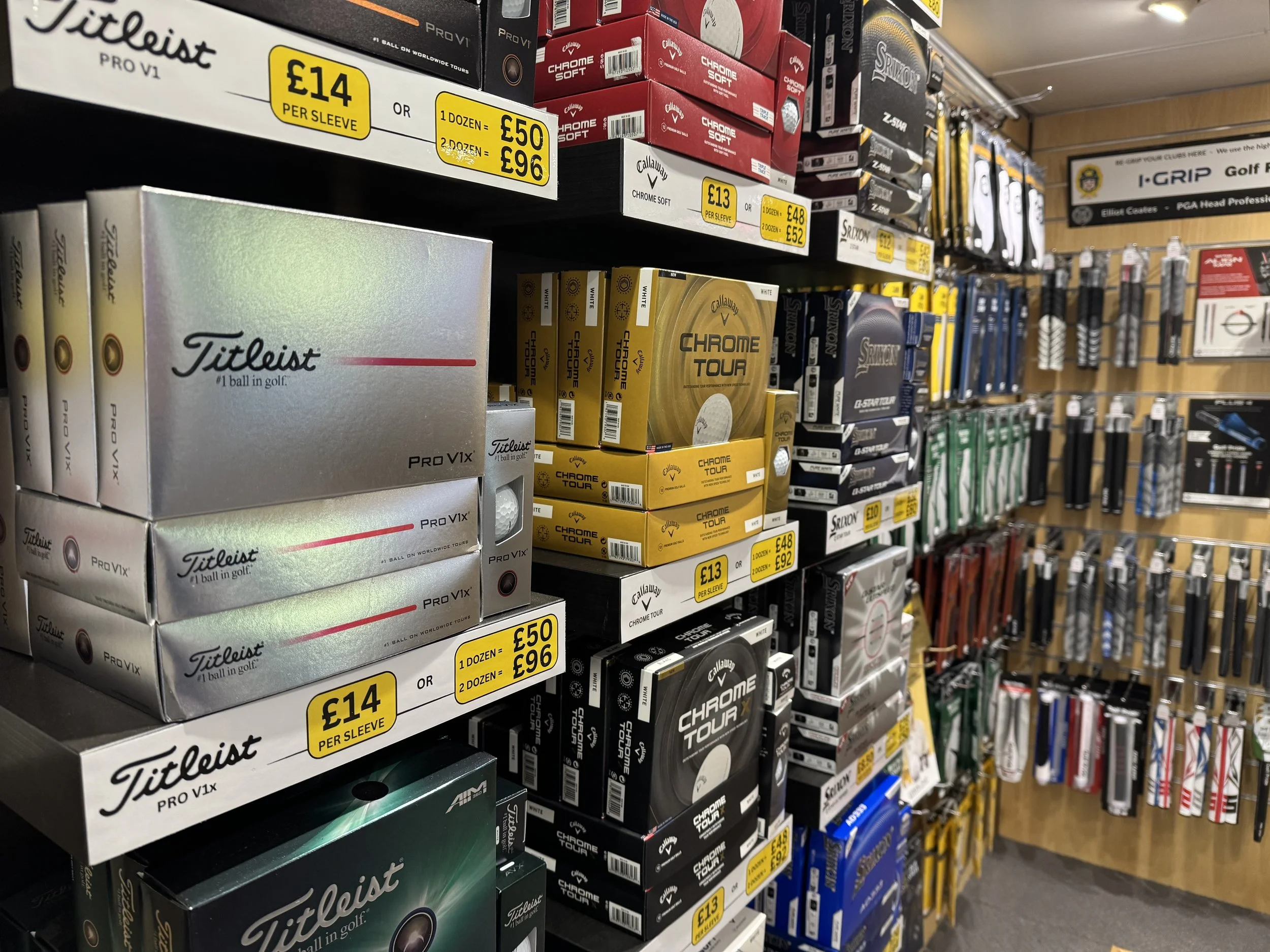 Golf balls and golf accessories on store shelves at a sports equipment store.