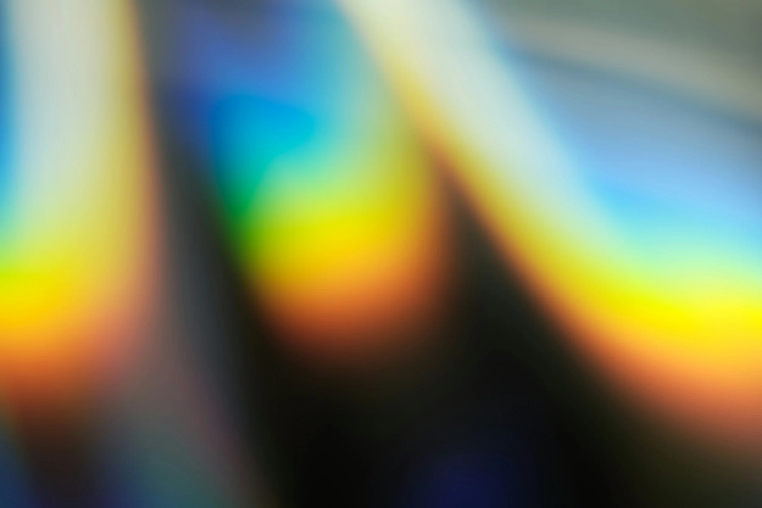 Blurred colorful background with shades of blue, green, yellow, orange, and black.