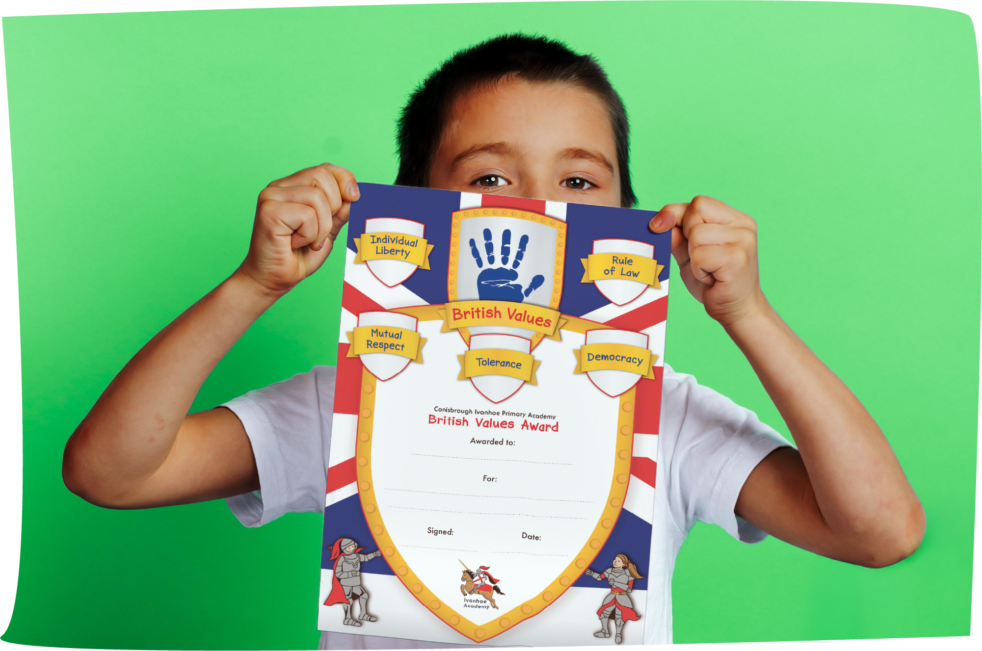 A young boy with short dark hair holding a British Values Award certificate partially covering his face, standing against a green background.