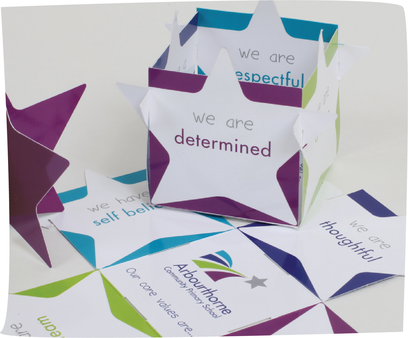 Brightly printed star shaped cubes  featuring Arbourthorne Community Primary School's core values including "we are determined" and "we are respectful," promoting self-belief and school community connection