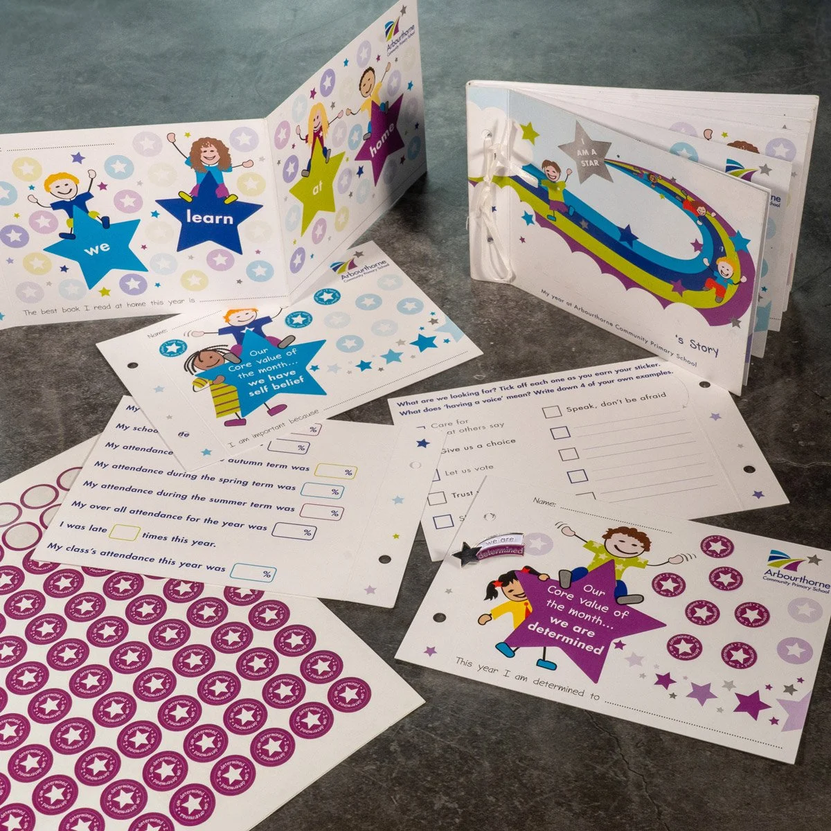 Collection of colorful school worksheets and activity pages with stickers, featuring children and star-themed designs from Arbourthorne Community Primary School.
