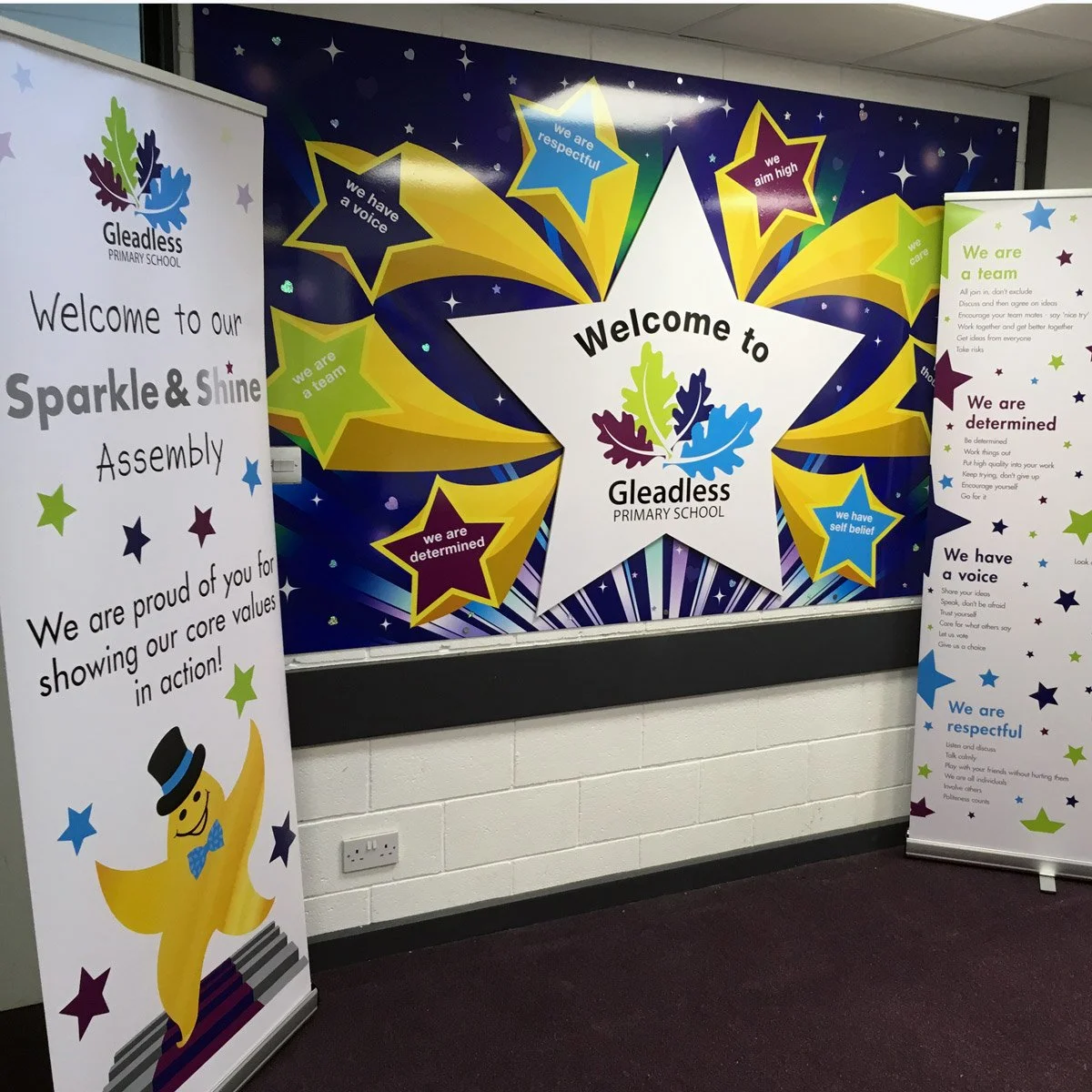 School hallway with colorful Star-themed banners and posters for Gleadless Primary School, welcoming students with core values like respect, self-belief, determination, team spirit, high aims, and caring.