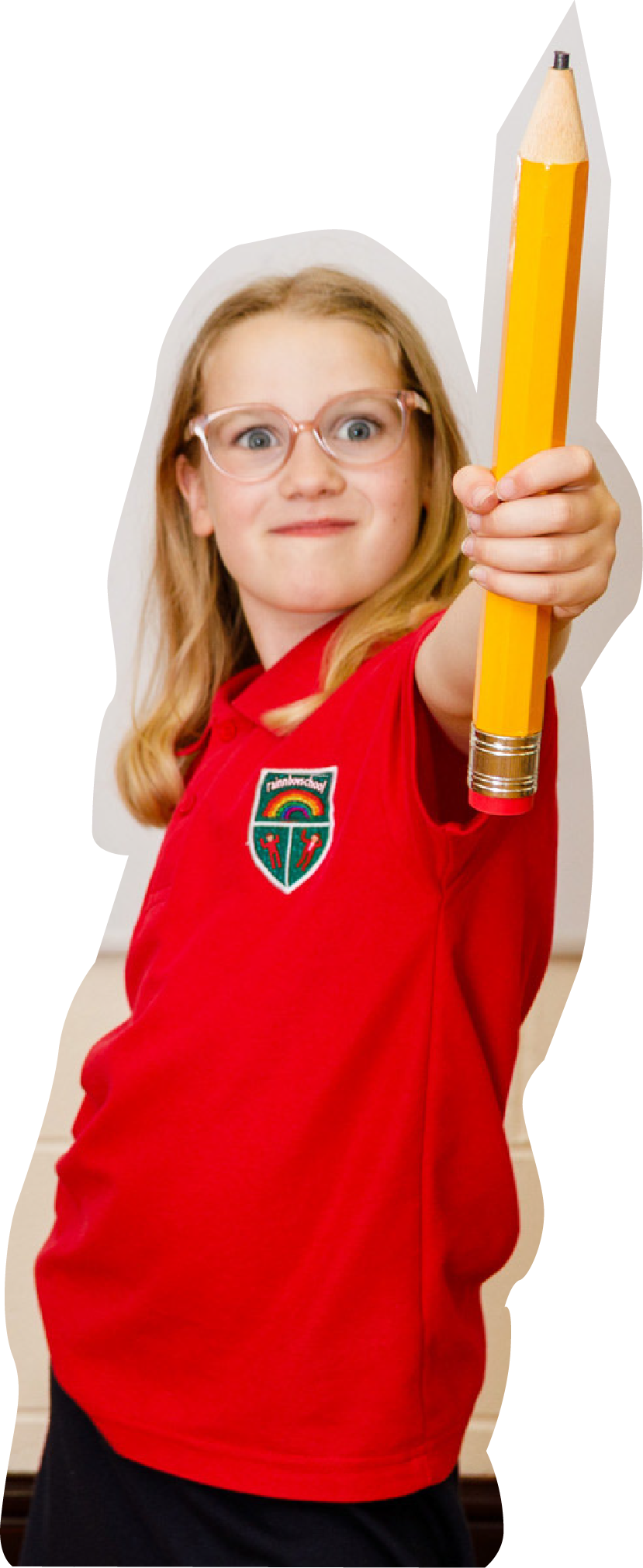 A young girl with glasses and long blonde hair is holding an oversized yellow pencil towards the camera with a confident expression. She is wearing a red polo shirt.