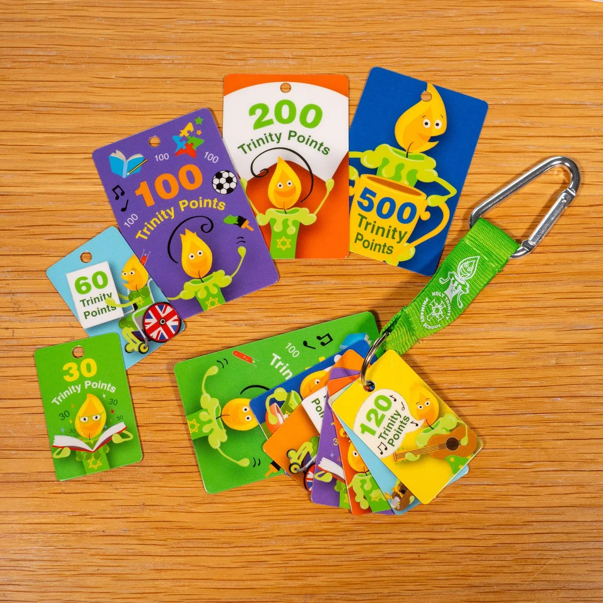 Colorful Trinity Points cards with a lanyard and clip on a wooden surface.