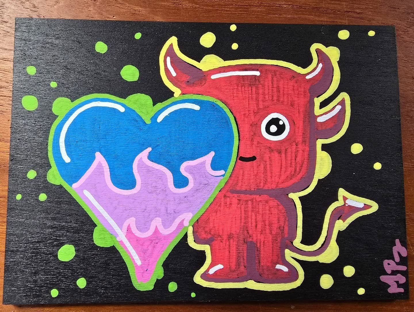 Colorful drawing of a red cartoon bull with a big eye and a small smile, holding a multicolored heart with blue, pink, and purple sections, on a black background with green dots, signed 'H.P.' in pink.