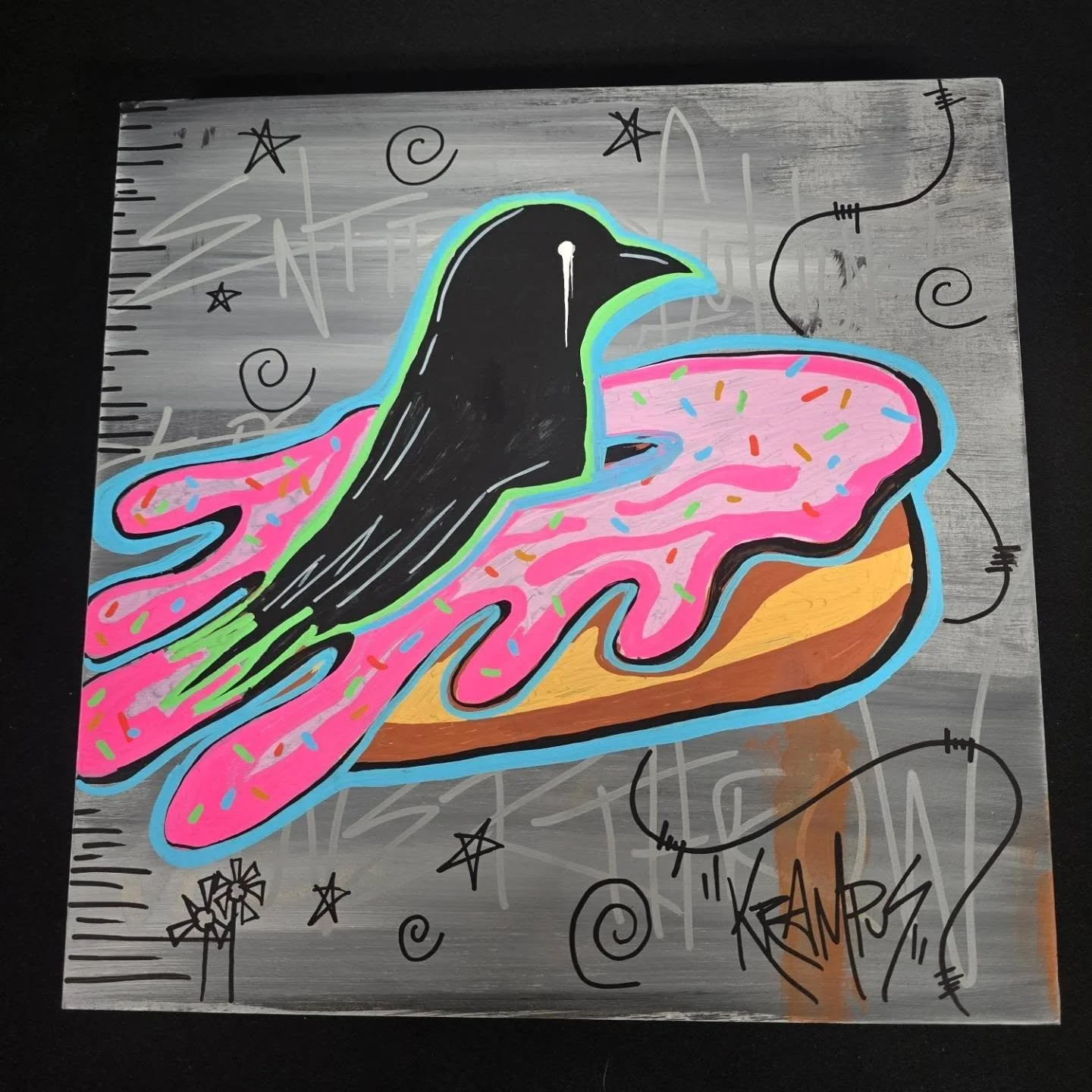 Graffiti-style artwork of a black penguin with a colorful, splattered pink background, surrounded by stars and sketches on a metallic gray surface.