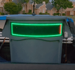 Front view of a digital sign displaying a green rectangle with an orange slash on the right side, mounted on a vehicle displaying Feed Mr. Trashy™