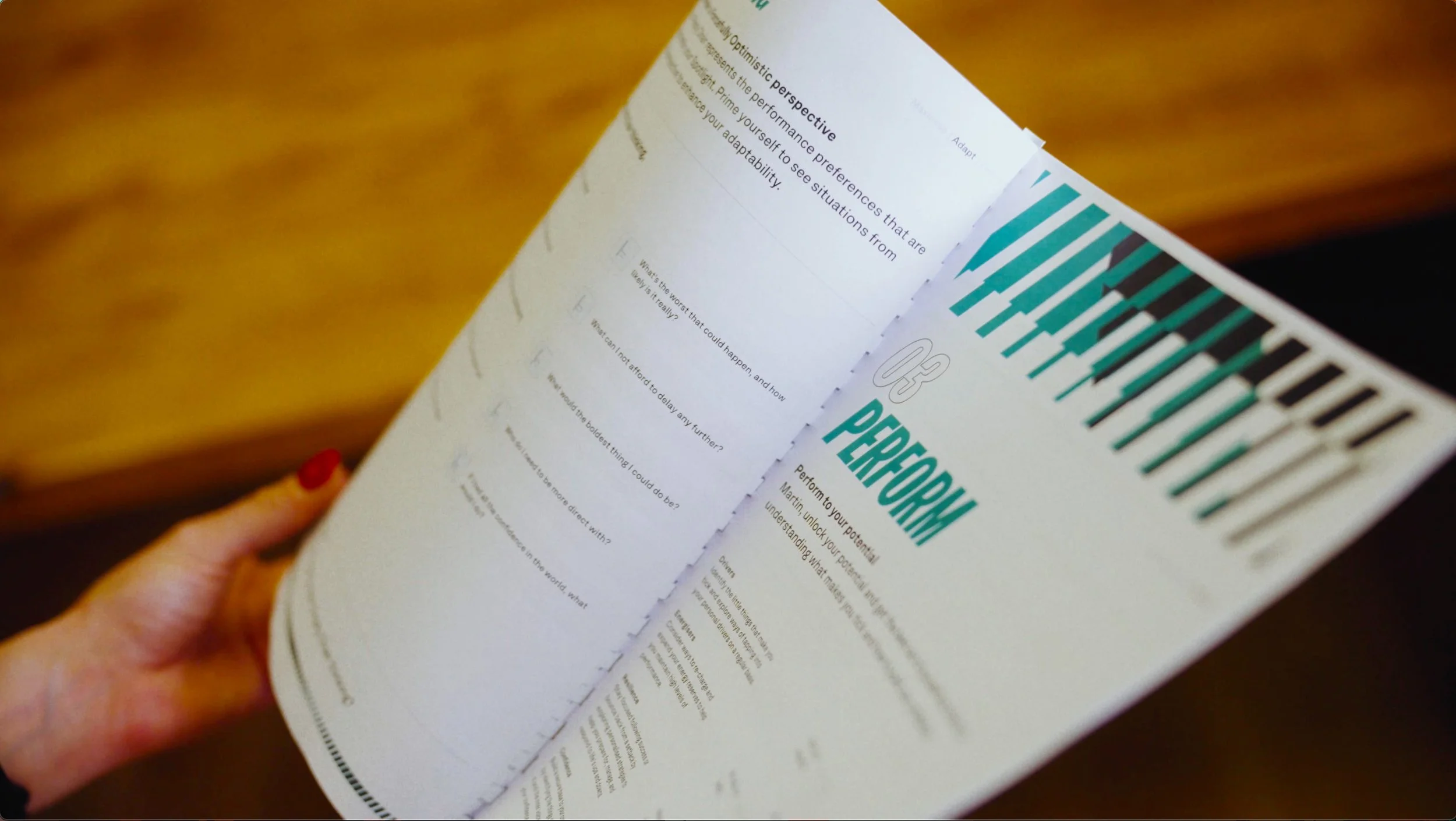 Carol Castle Leadership Coaching Close-up of a printed pamphlet titled 'PERFORMANCE' with a person holding it, showing text about optimizing performance and adaptability.