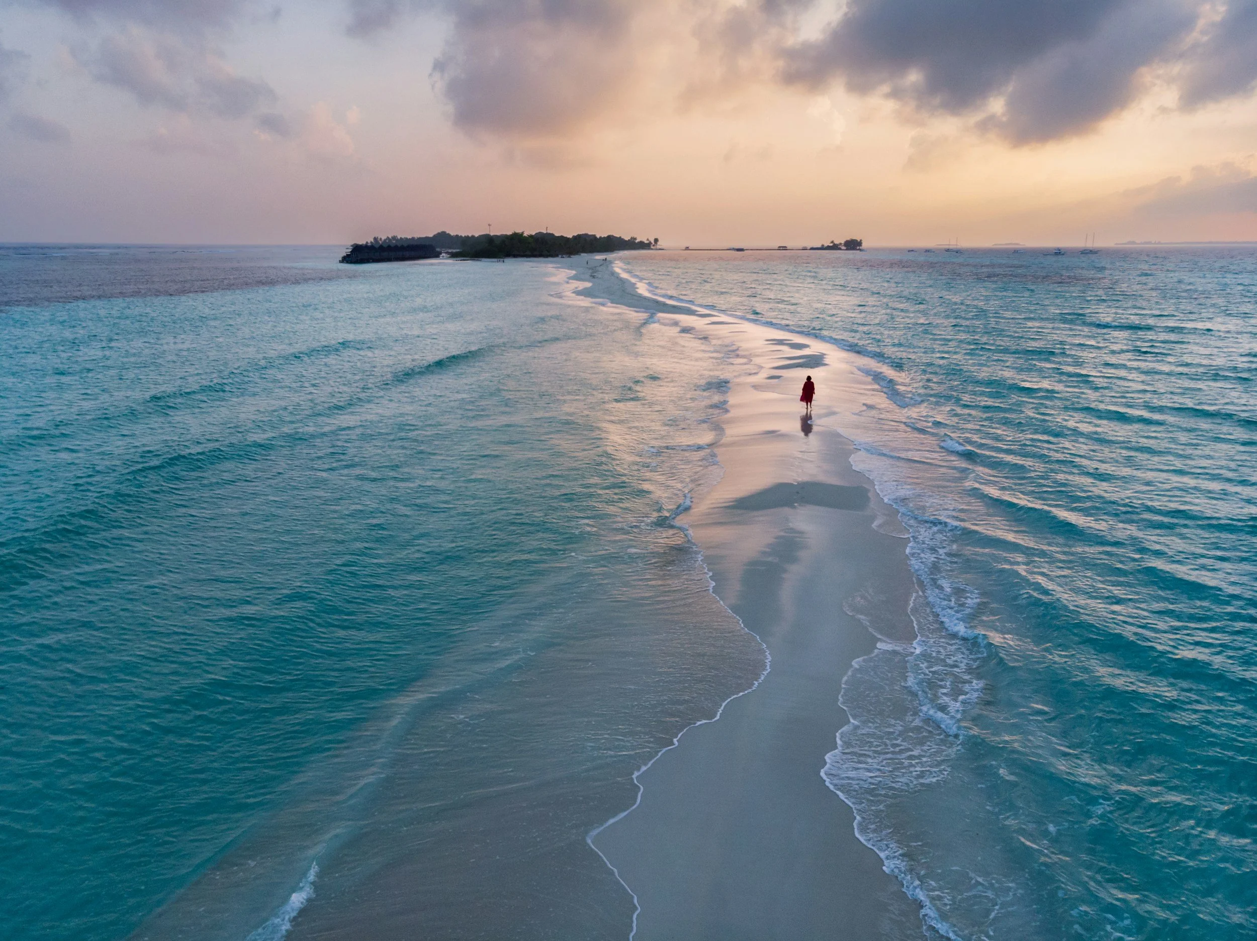 Sunset walk on an ocean sandbar — Maldives.