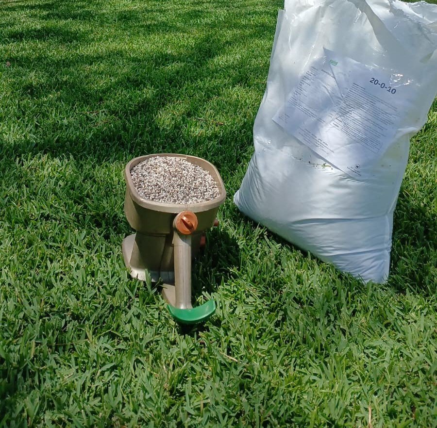 A bag of fertilizer and a fertilizer spreader.