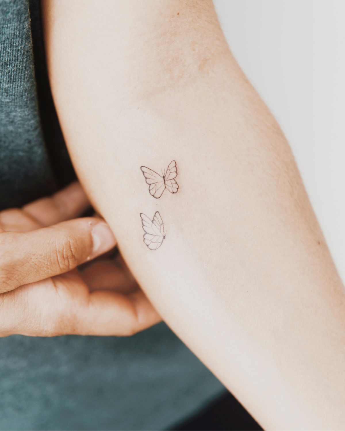 tatuaje fine line mariposas brazo