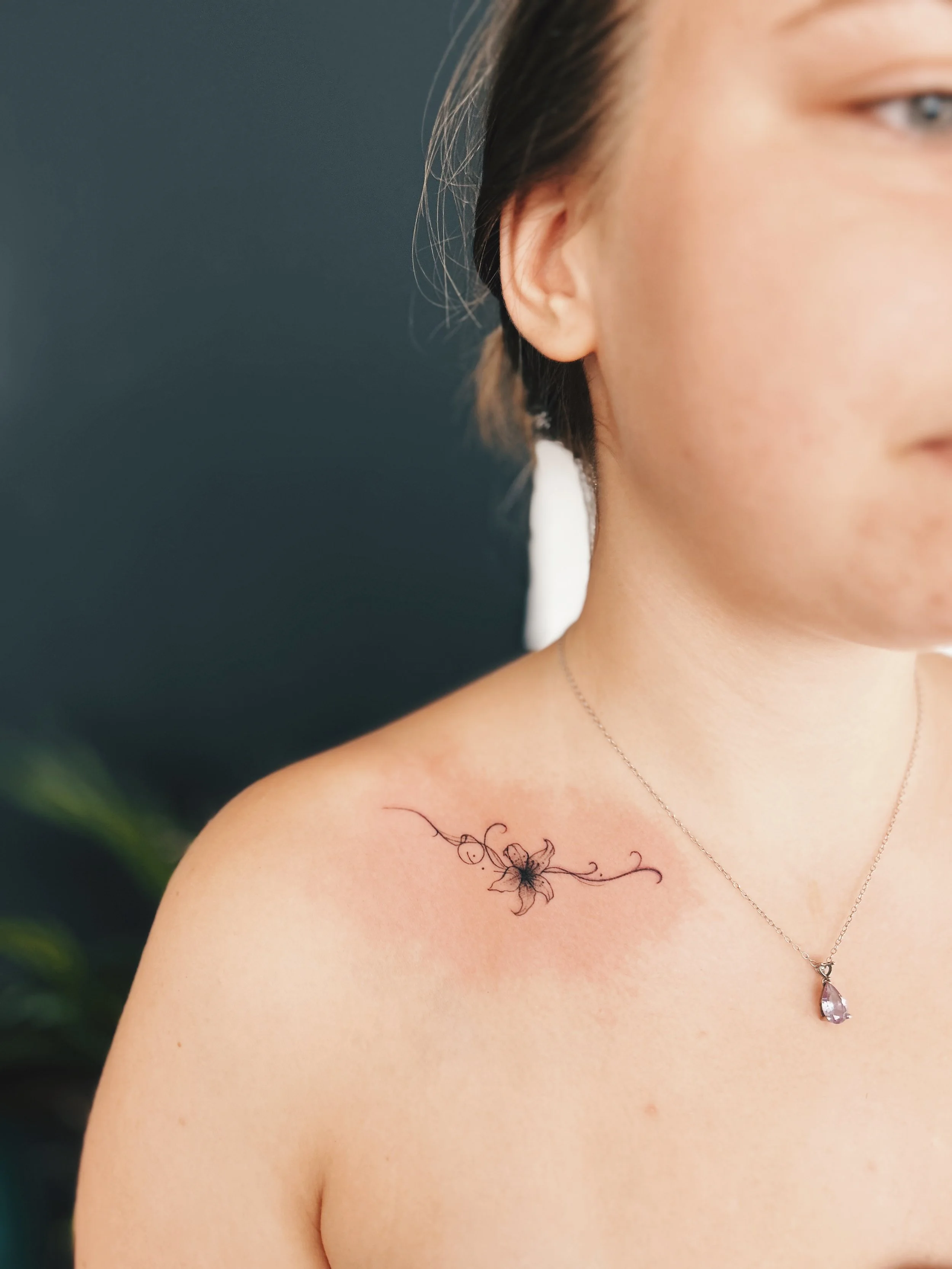 tatuaje fine line flor clavicula