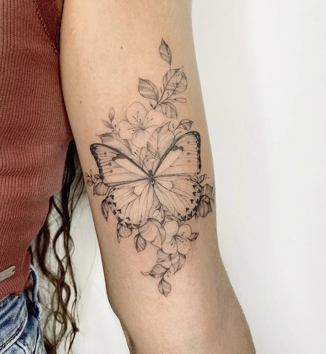tatuaje botánico mariposa brazo