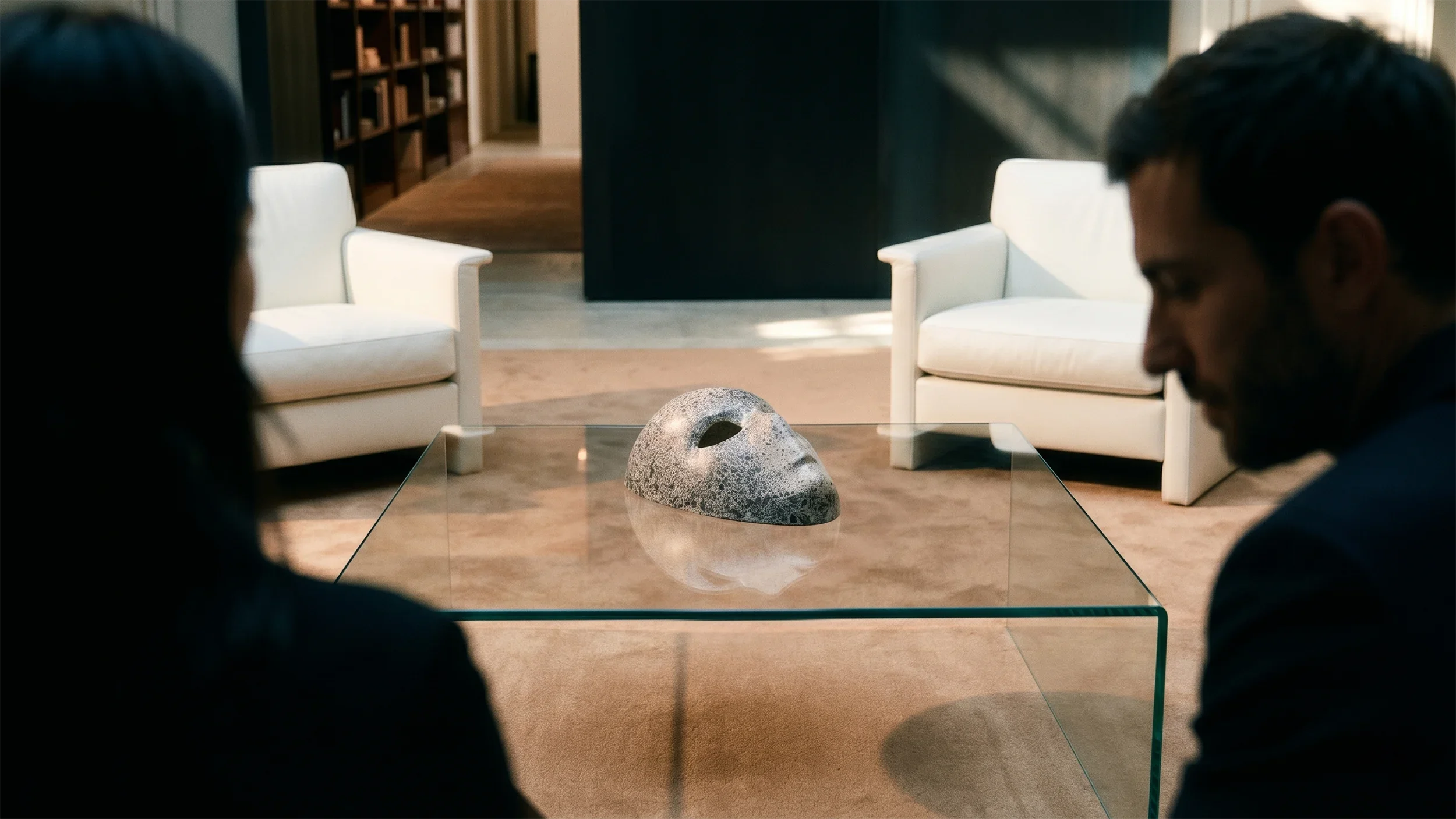 Maschera in cartapesta decorata con magnesite firmata Ivan Ricupero, esposta su un tavolino in vetro all'interno di un salotto contemporaneo. Un pezzo unico di collectible design che diventa fulcro visivo e dialoga con lo spazio architettonico.