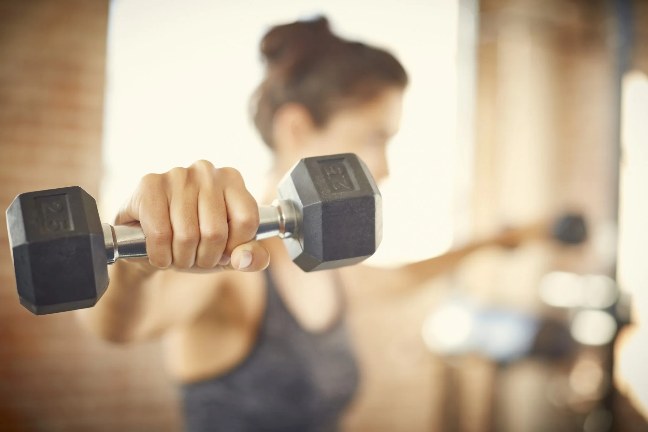 A person holding a dumbbell while working out in a gym.  Personal Training for the over 50's. Ramsbury, Wiltshire.
