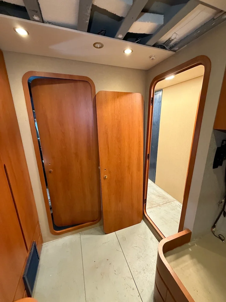 Wooden doors and doorframe inside a room with ceiling recessed lights and an exposed ceiling.