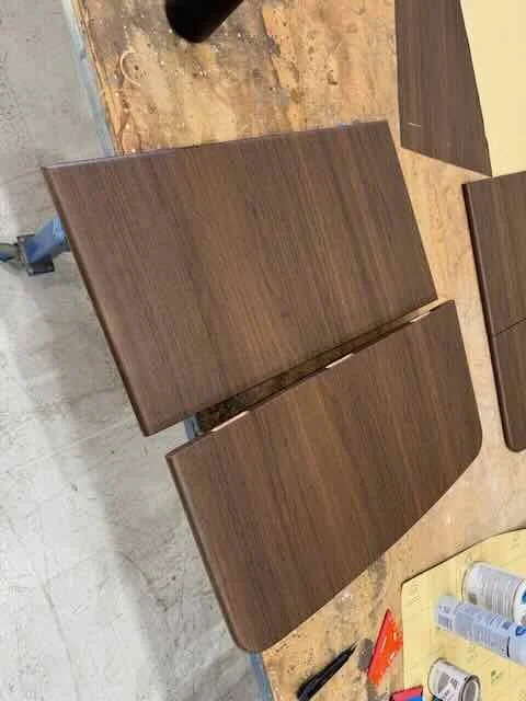 Two unfinished wooden table boards on a workbench in a woodworking shop.