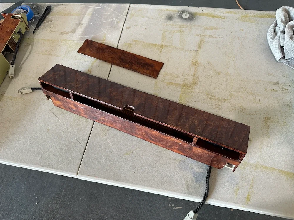 A wooden cabinet and a wooden panel on a workbench in a workshop.