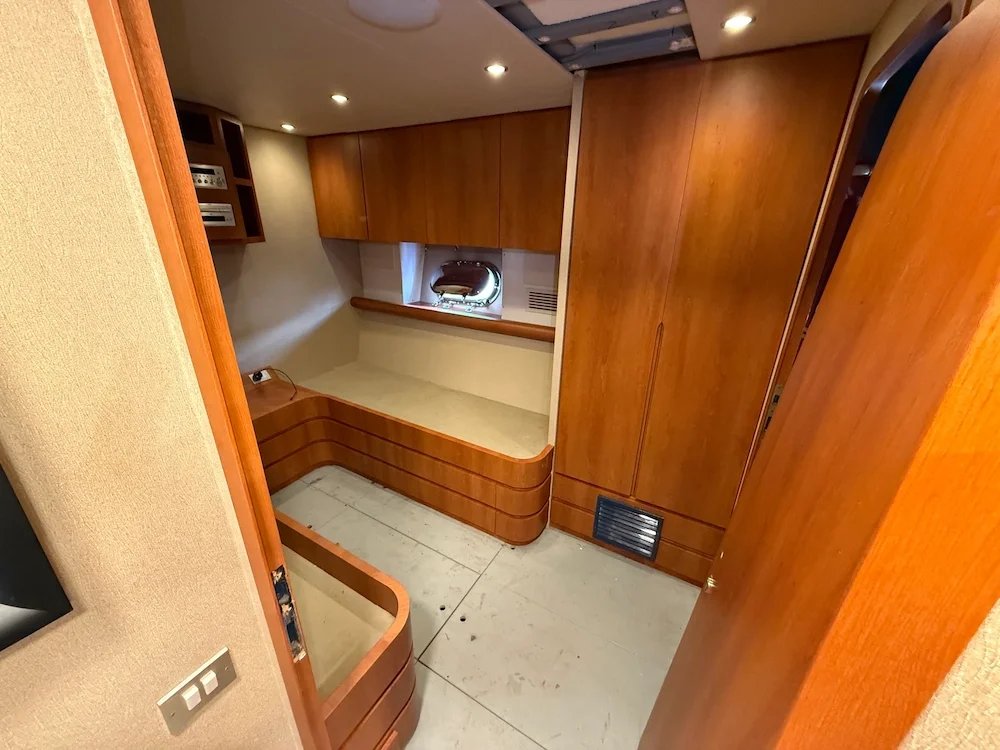 Interior of a boat cabin with wood-paneled walls and built-in furniture.
