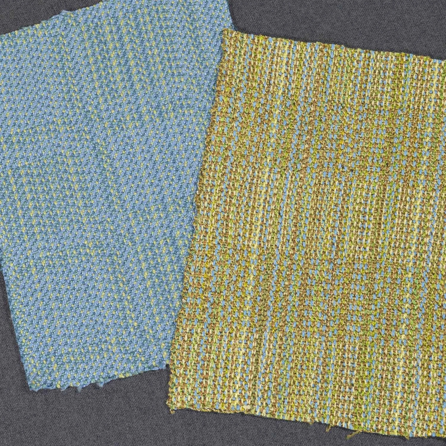 Two colorful handwoven fabric samples, one with blue, yellow, and green threads on the left, and the other with yellow, green, and blue threads on the right, lying on a dark fabric background.