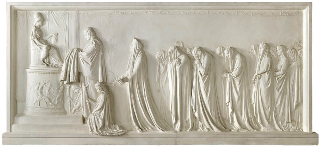 A white stone relief sculpture depicting a historical or religious scene with multiple figures, some standing and others seated, engaged in an event.