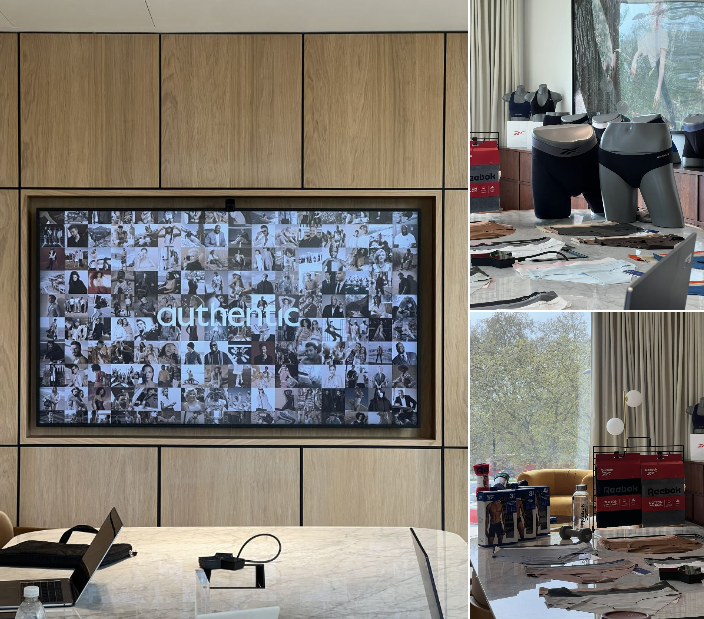 Office conference room with a large screen displaying the word 'authentic' made up of smaller black-and-white photos.
