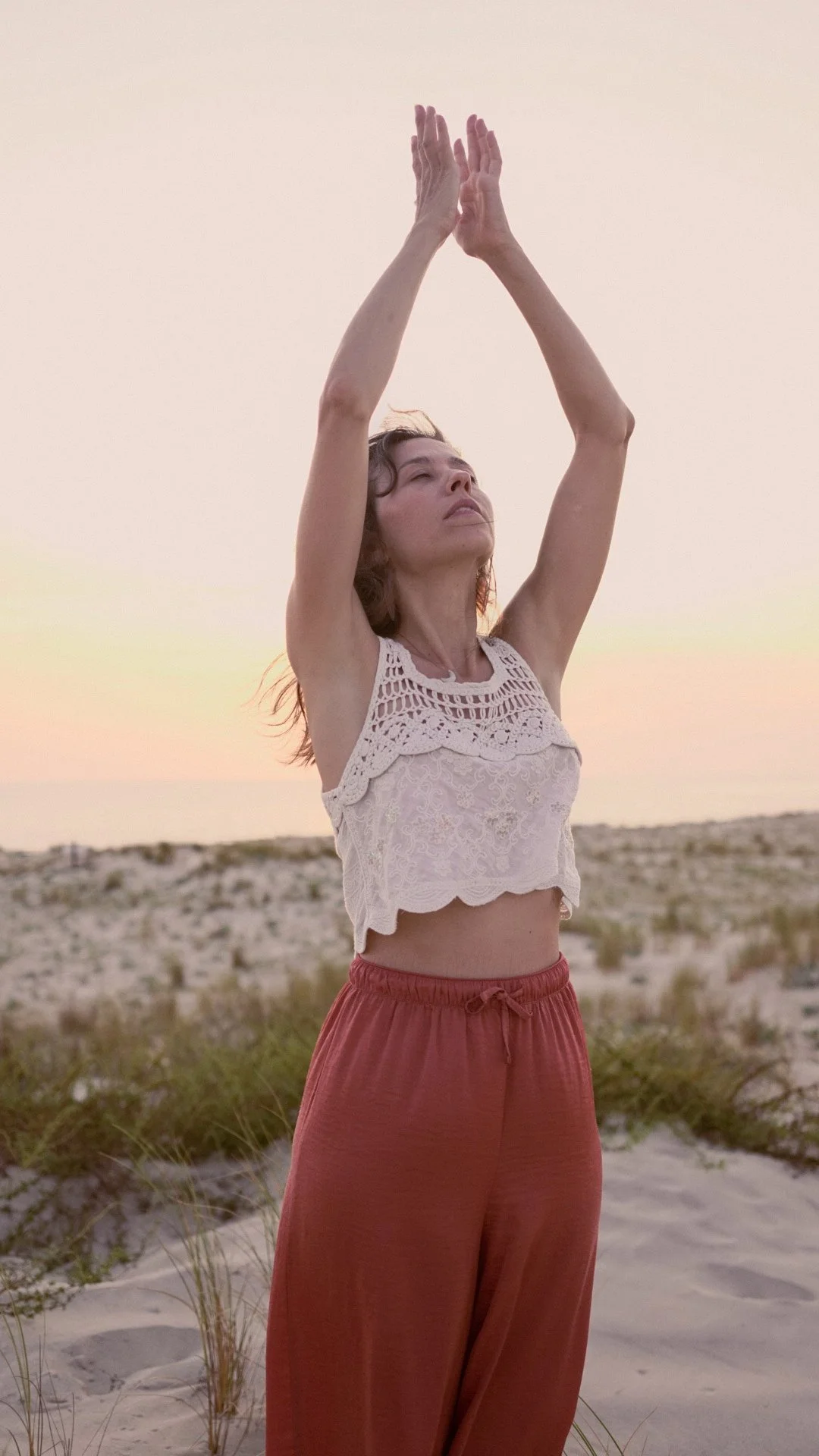 Éloïse bras levés face au soleil, dans les dunes, connexion au corps