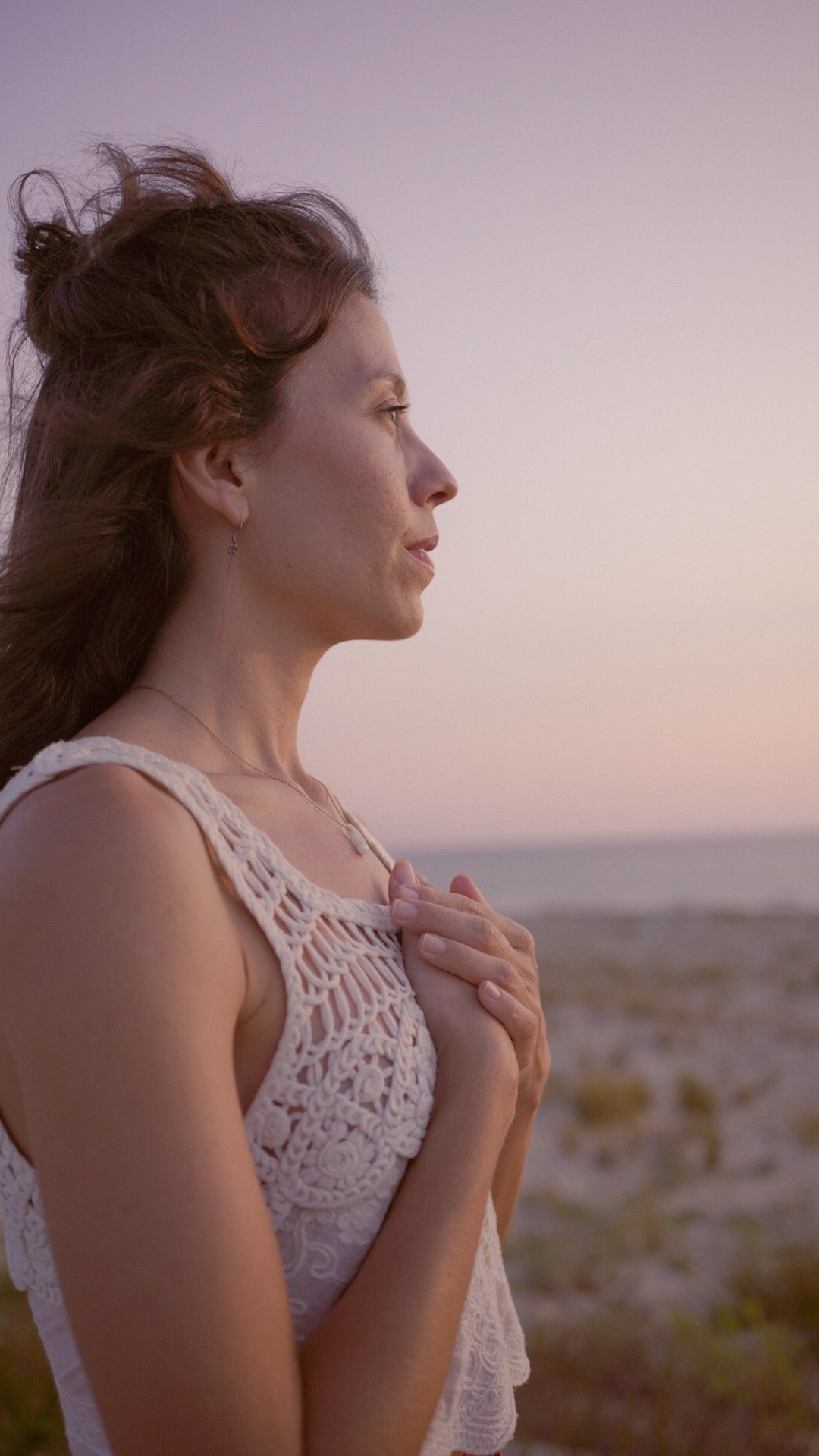 Éloïse les mains sur le cœur, regard tourné vers l'horizon