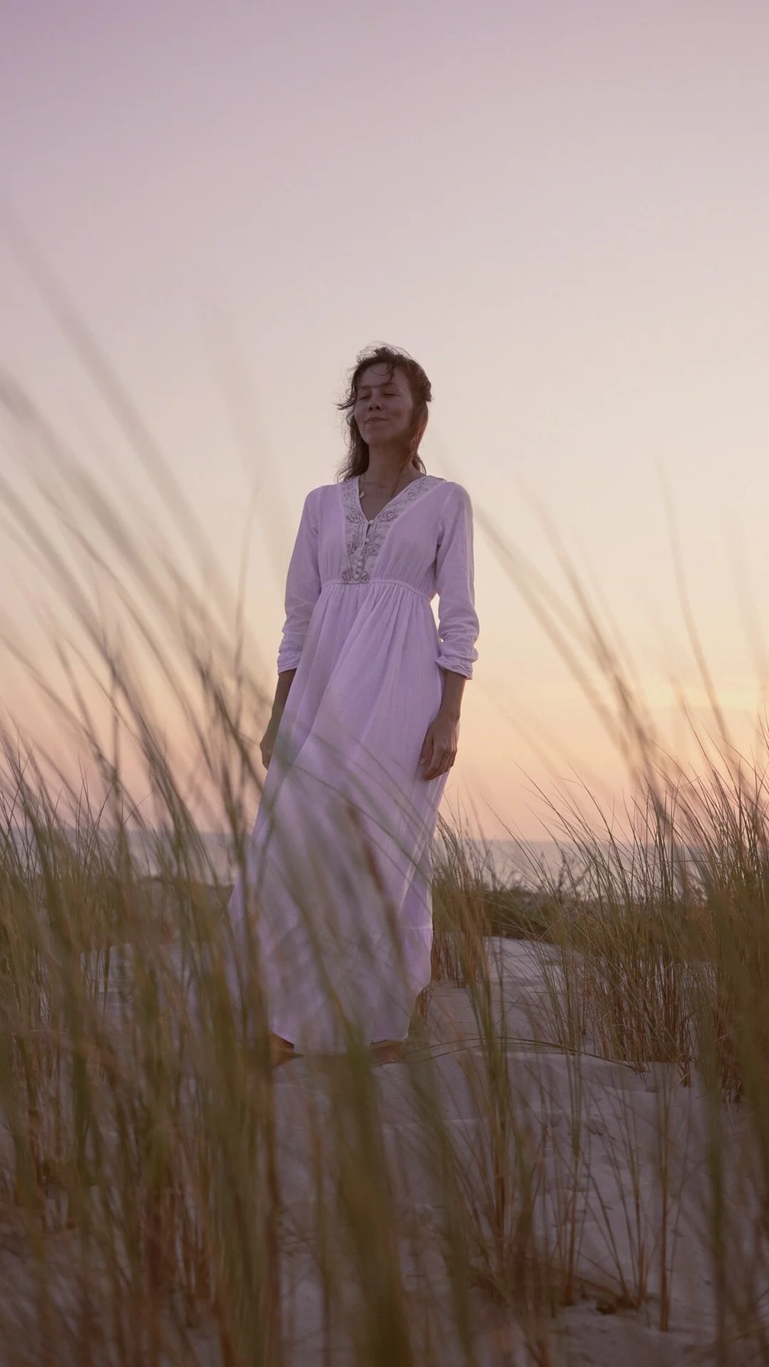 Éloïse debout dans les dunes au coucher du soleil