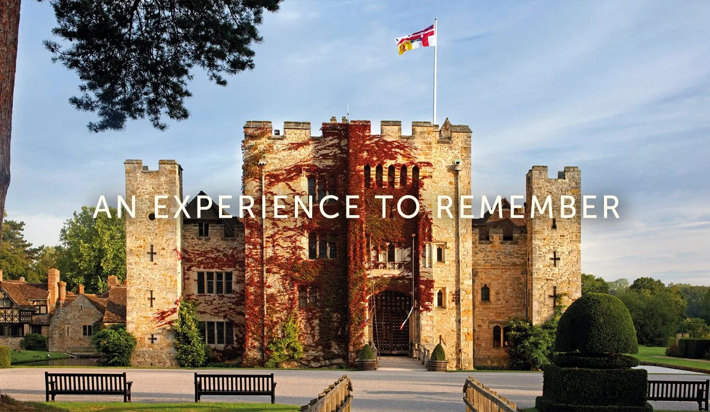 Front view of a castle with a flag on top, surrounded by greenery and benches, with the words 'An Experience to Remember' overlaid.