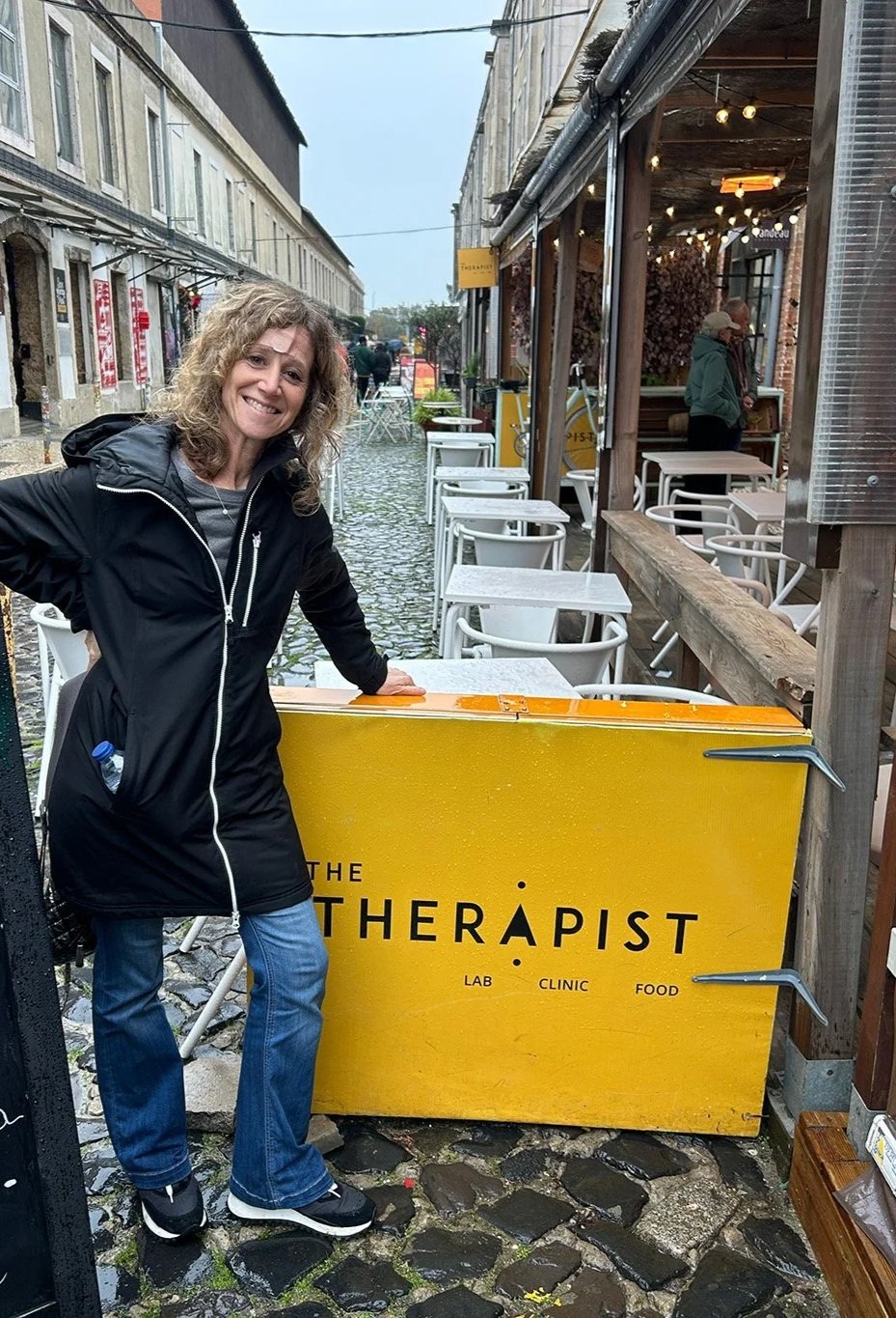 Emily in front of a restaurant named The Therapist