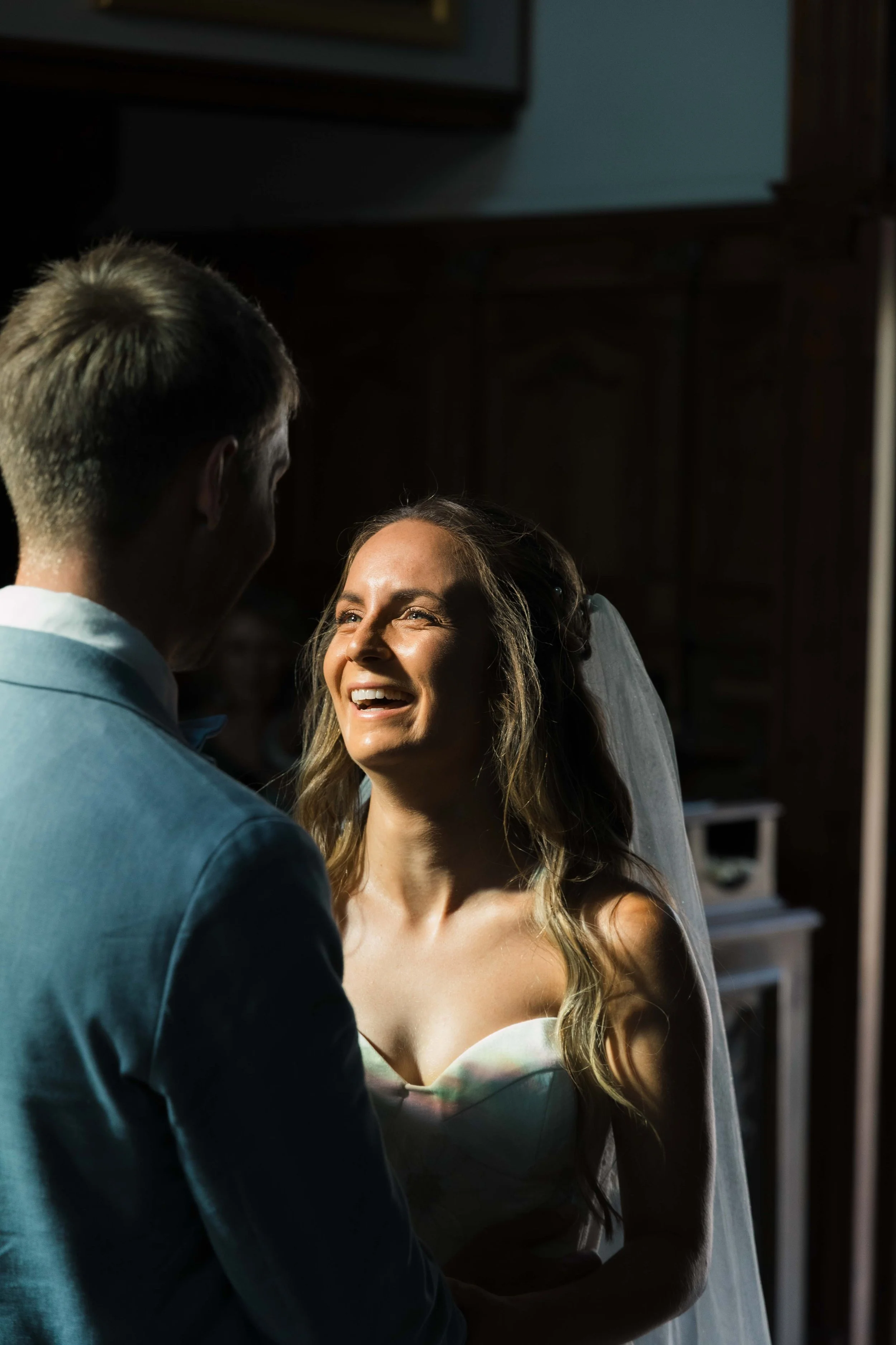 Bride and groom sharing a loving moment during their wedding ceremony, with the bride smiling and looking joyful.