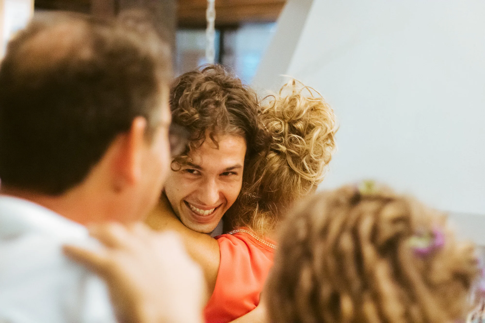 A group of people hugging, with one person smiling.