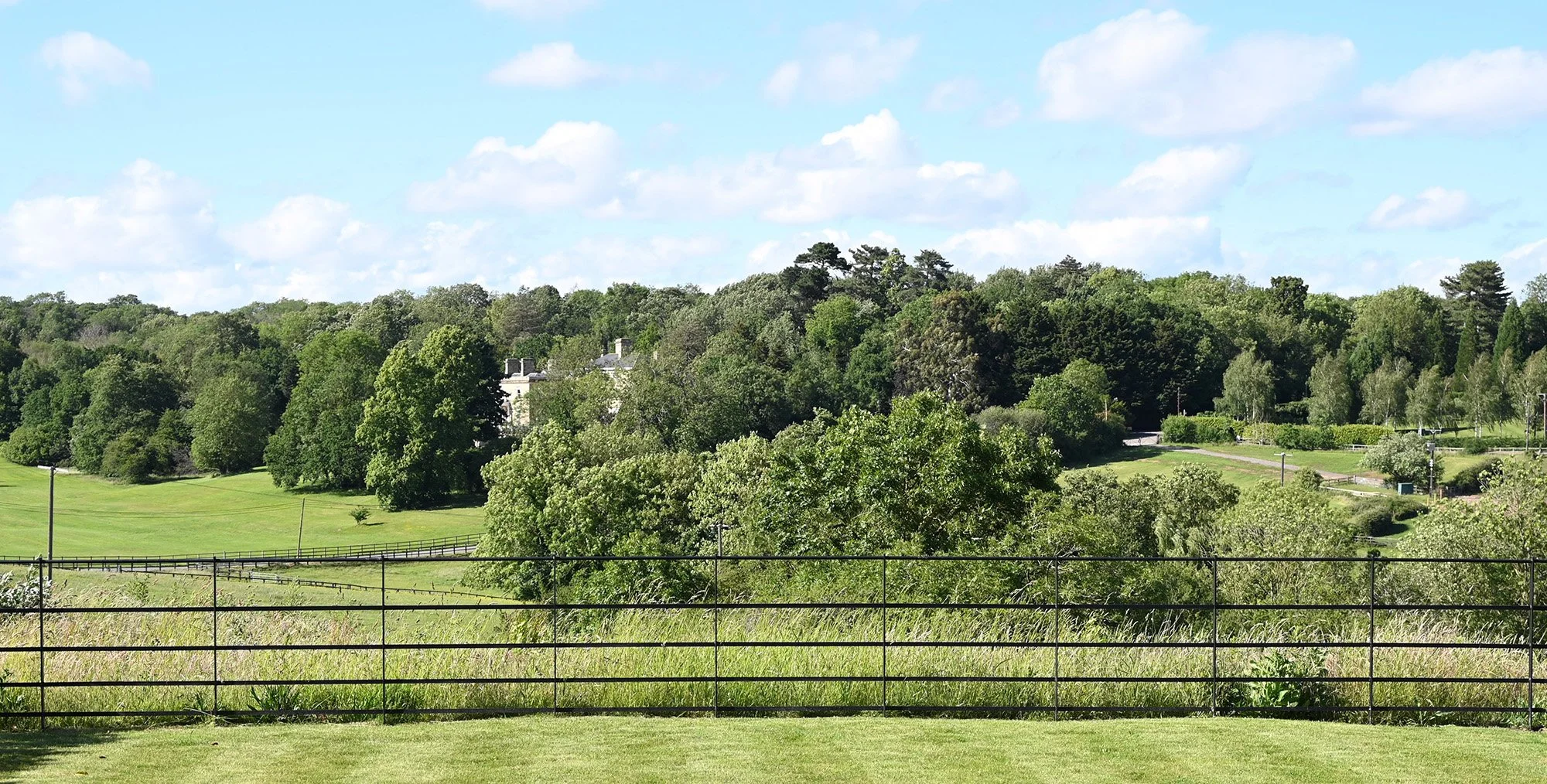 Landscape view across private gardens and countryside showing natural green spaces.