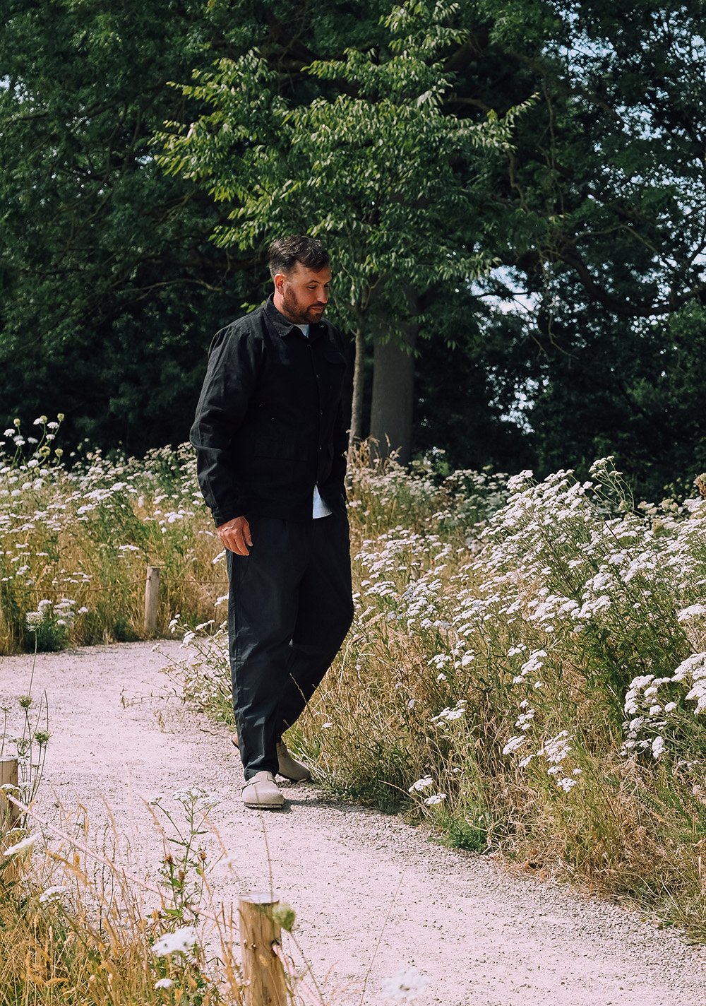 Founder Benjamin Tyler inspecting a private garden as part of professional garden management services.