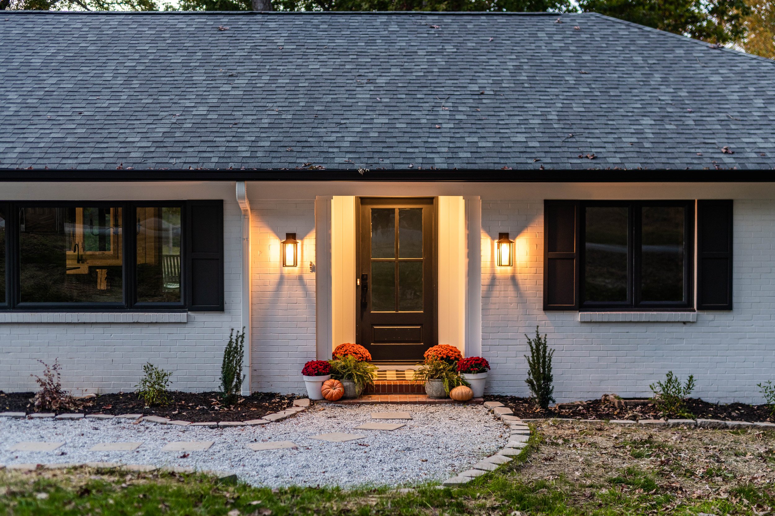 The outside of a newly renovated home with a new gravel walkway and a new front door in Greenville, South Carolina