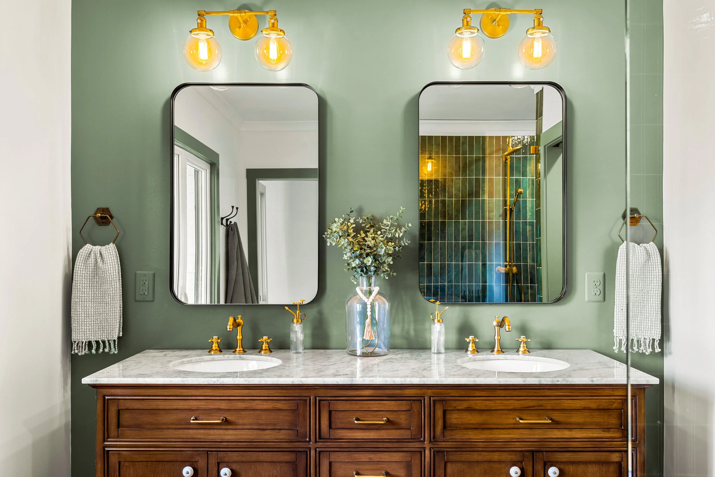A luxury double vanity bathroom renovation with green paint and quartz countertops in Greenville, South Carolina 