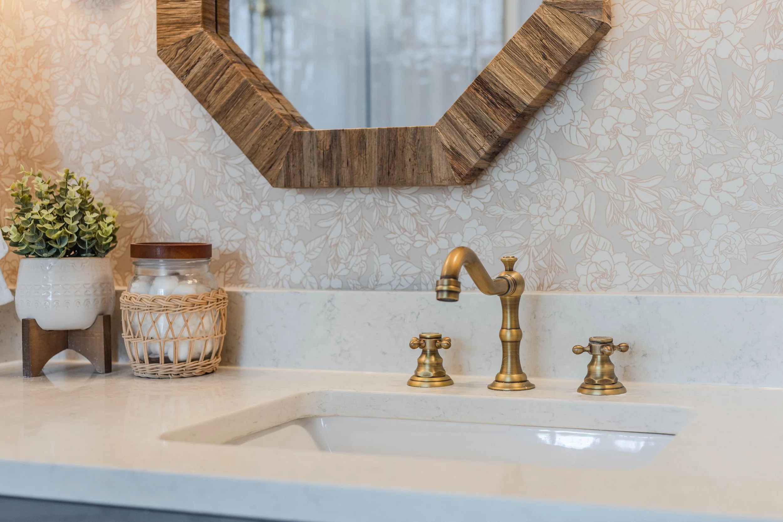 A detailed renovated bathroom counter with brushed gold faucets and quartz countertops in Greenville South Carolina 