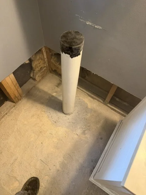 Plumbing rough-in with a capped pipe in an unfinished room