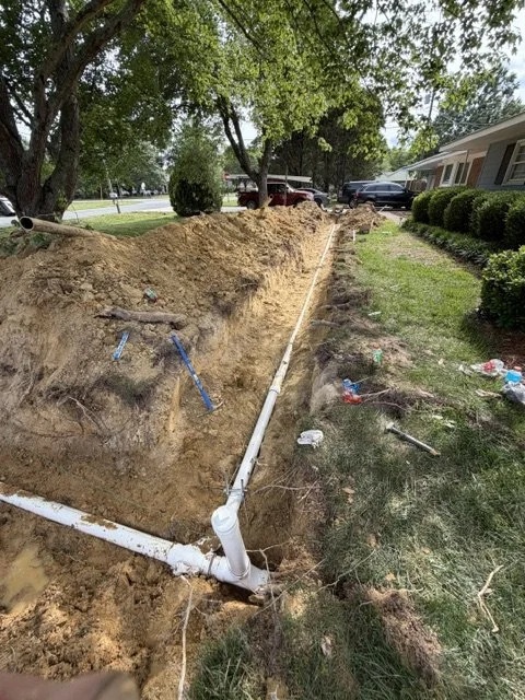 New underground pipe installation along a trench in a residential yard