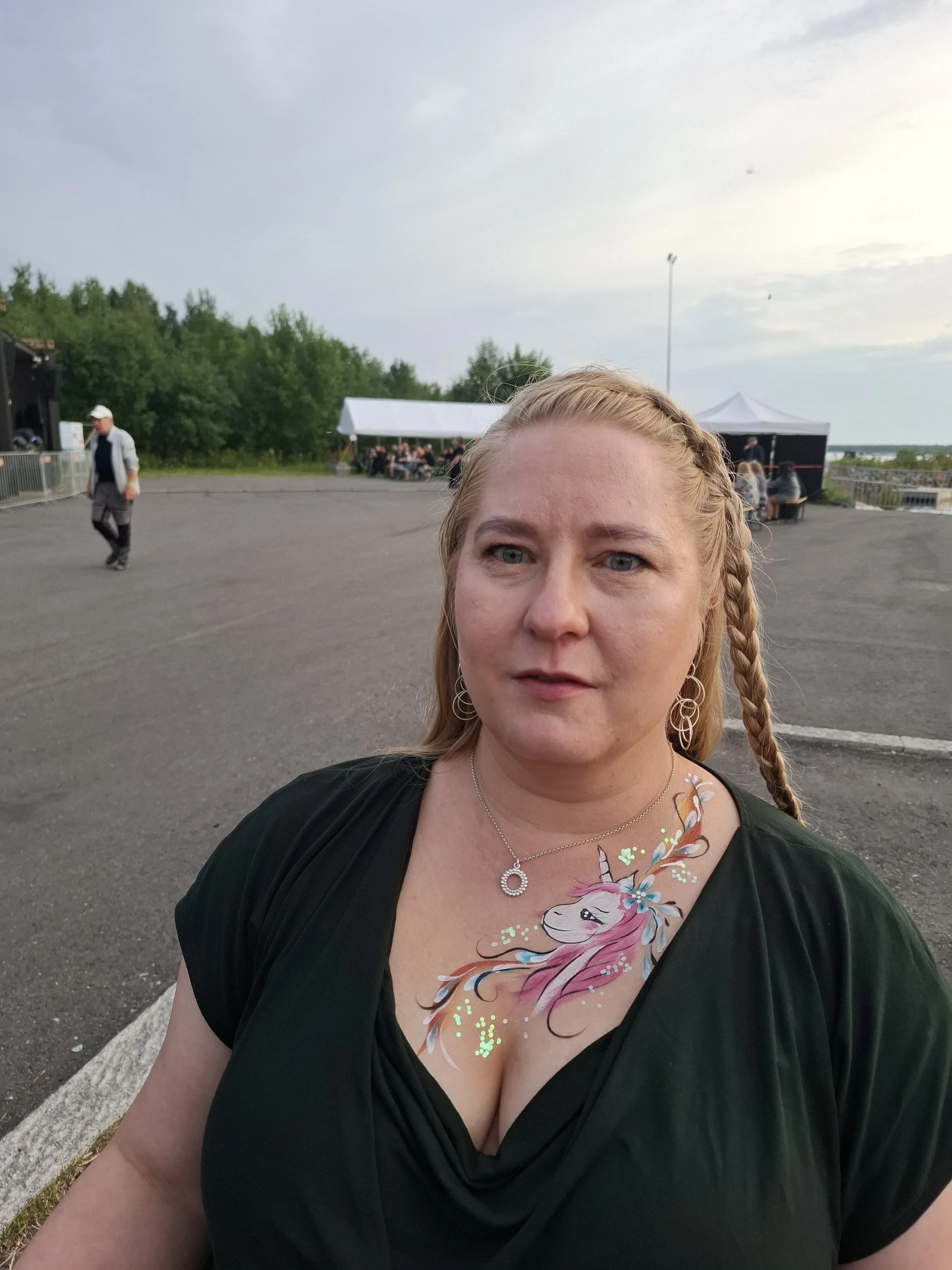 Nainen festivaaleilla, jolle on tehty ihomaalaus rintakehälle. 