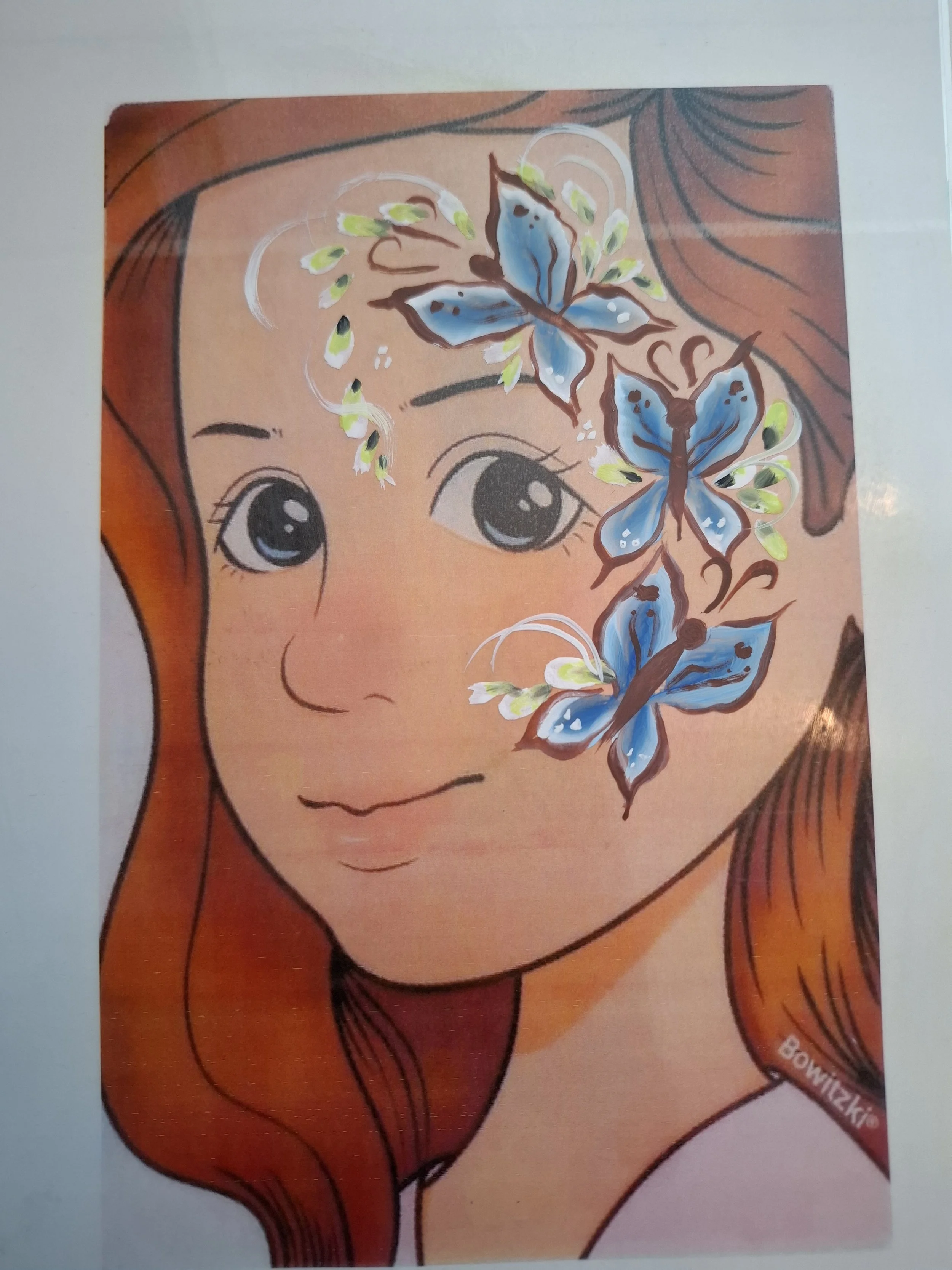Harjoituspohjalle tehty maalaus jossa on maalattu sinisiä ja valkoisia perhosia, joissa on keltaisia ja vihreitä yksityiskohtia.