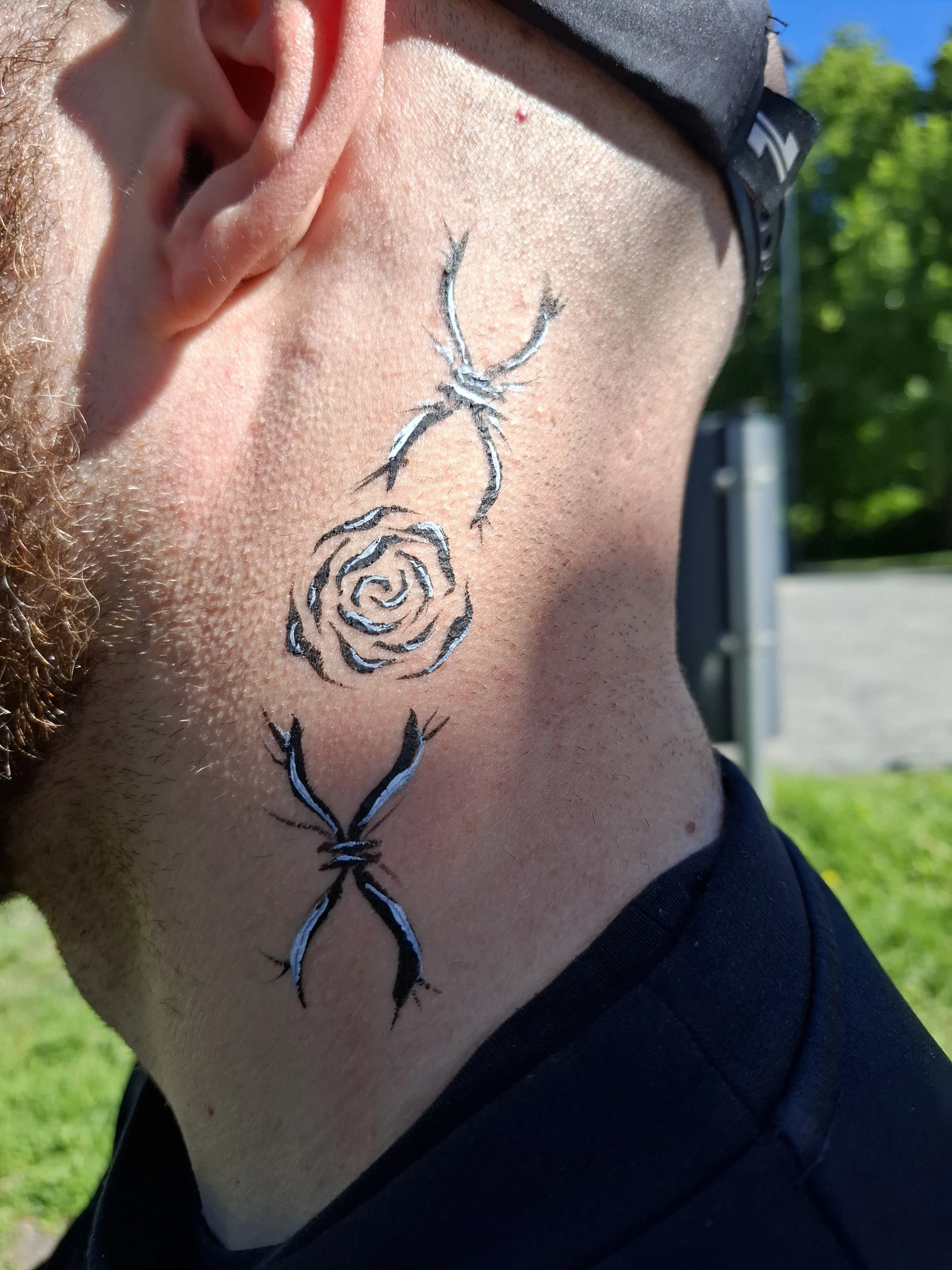 Asiakkaan kaula ja rintaosaa, jossa on mustavalkoinen ihomaalaus.
