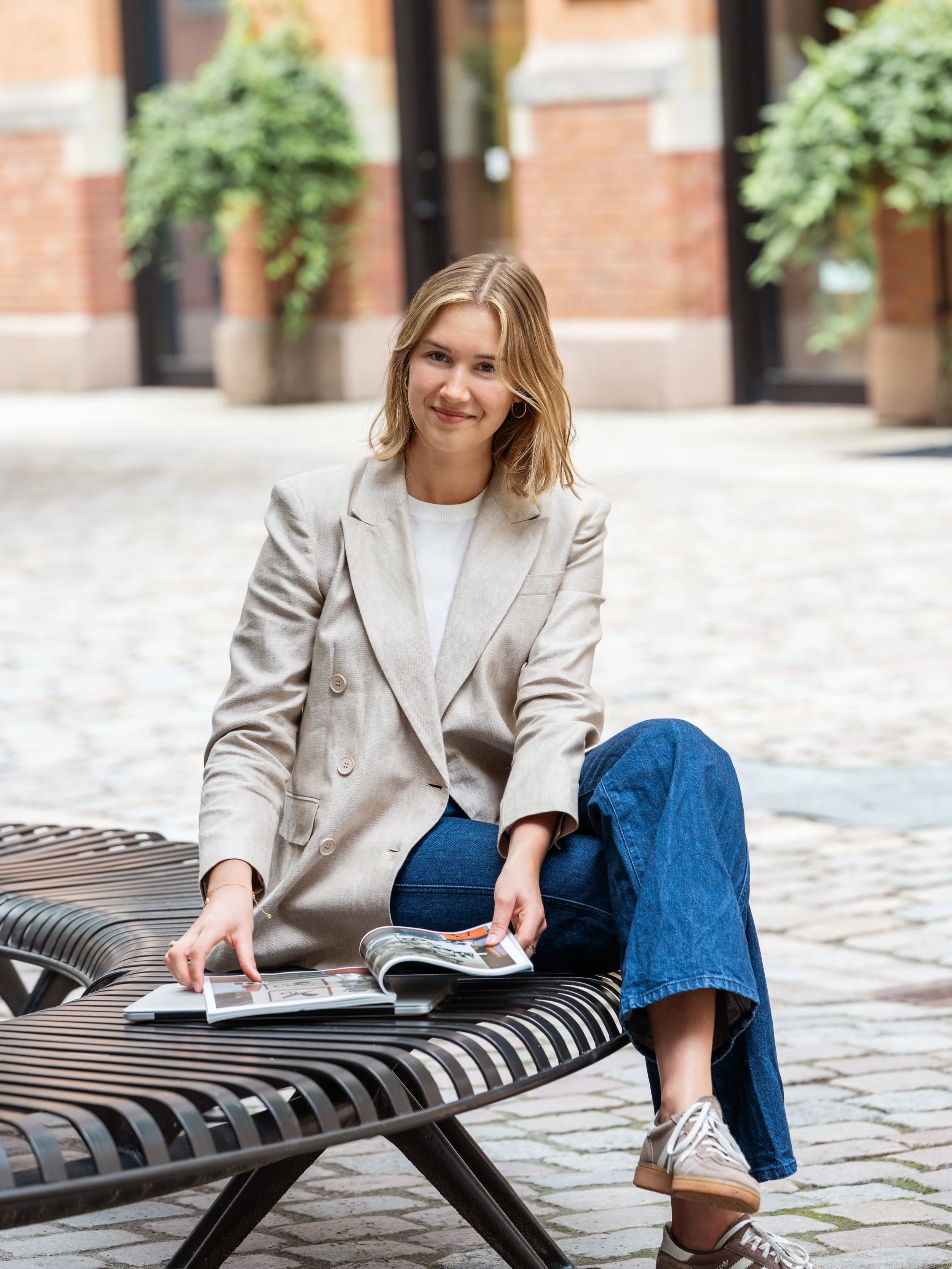ceo founder ann-marie sitting on bench with lifestyle magazin