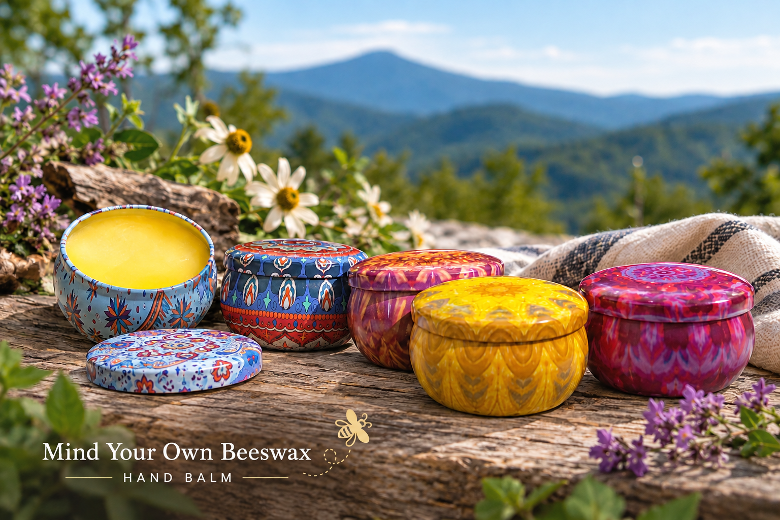 Colorful tins of Mind Your Own Beeswax hand balm displayed outdoors in the Blue Ridge Mountains of North Carolina.