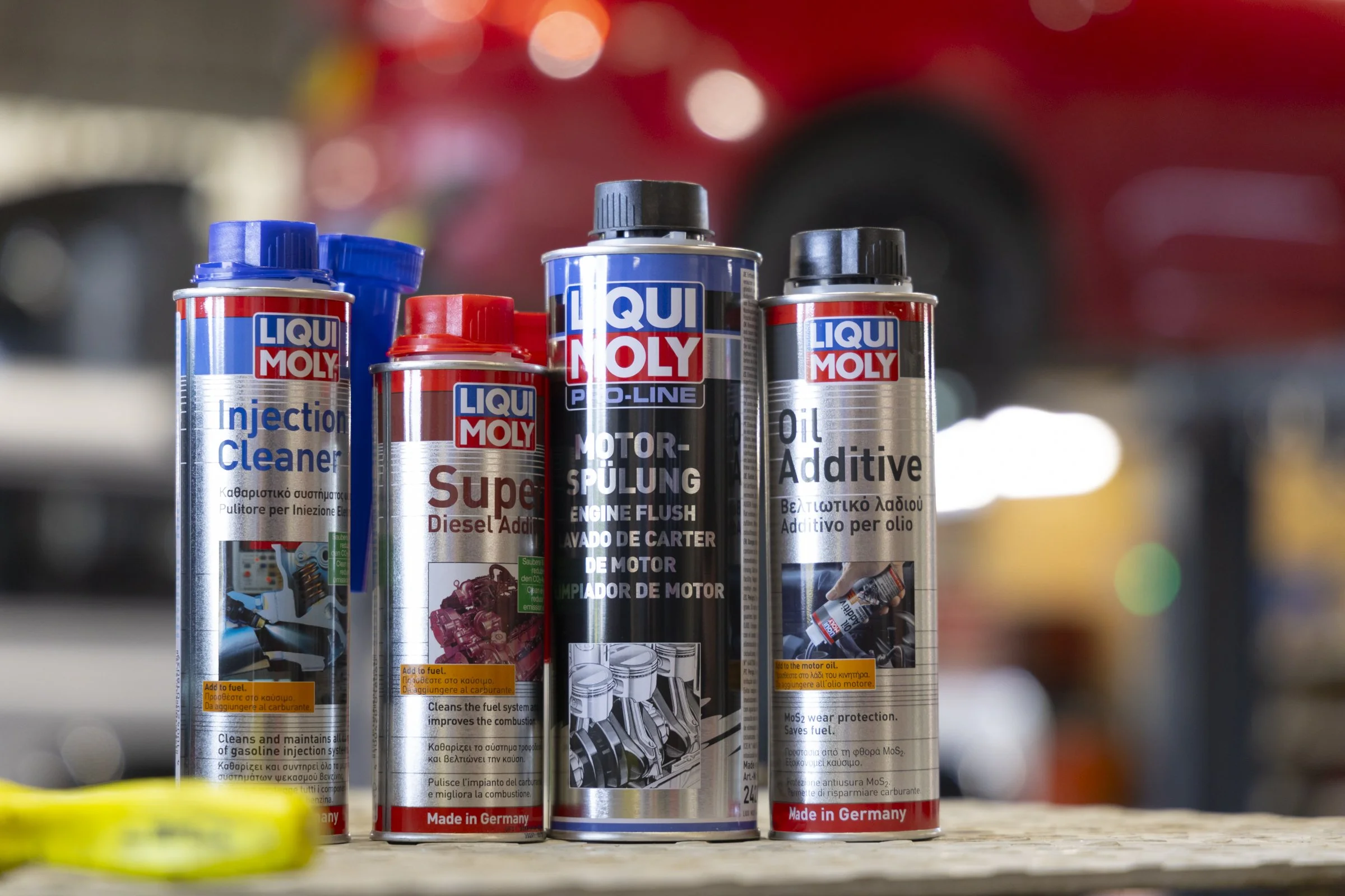 Collection of Liqui Moly automotive products including engine oil, fuel additive, and engine flush bottles on a shelf.